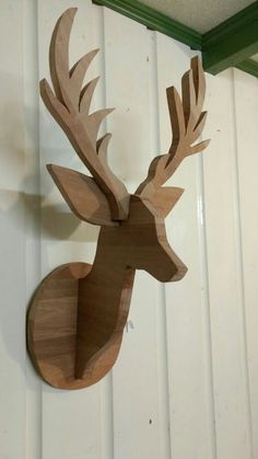 a wooden deer head mounted to the side of a wall