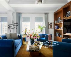 a living room filled with blue couches and a flat screen tv