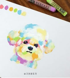 a drawing of a colorful dog on paper with markers and crayons next to it