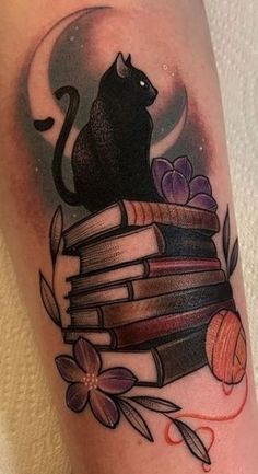 a black cat sitting on top of a stack of books with flowers and leaves around it