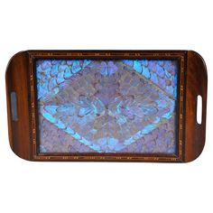 an ornate wooden tray with blue and pink designs