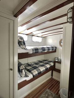 two bunk beds in a small room with wood flooring and white walls on either side