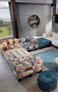 a living room filled with lots of furniture and a large window over looking the ocean