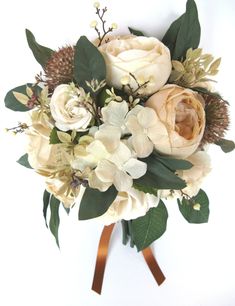 a bridal bouquet with white flowers and greenery on a brown ribbon tied around it