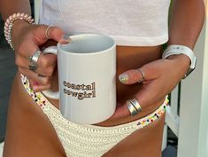 a woman holding a white coffee mug in her right hand with the words central cowgirl on it