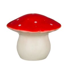 a red and white mushroom sitting on top of a table