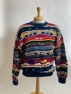 "Pre 1987 Australian men's Cuggi 100% wool knit sweater( Cuggi changed it's name to Coogi in 1987 to sound more Australian)with horizontal woven geometrics is labeled a size Large and is in very good condition, no holes or stains. Sweater has traditional 1980's dolman sleeves. Shoulders 25\" Chest 48\" Waist 34\"-36\" Arm length from armpit to cuff 24\" Vintage garments have been previously worn and lovingly cared for, they may however have a blemish or two. Here at MadelonVintage, I try my very best to note all the details of each garment, although I may sometimes overlook things, which I do apologise for. Please do not expect perfection, unless stated so. Please make sure you check all the measurements of the garment before purchasing. Vintage garment sizes are not the same as those of t Vintage Wool Jacquard Knit Sweater, Vintage Multicolor Jacquard Knit Sweater, Retro Wool Sweater With Fair Isle Pattern, Random Clothes, Wool Knit Sweater, Australian Men, Coal Mining, Wool Knit, Wool Sweater