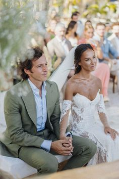 a man and woman sitting next to each other in front of a group of people