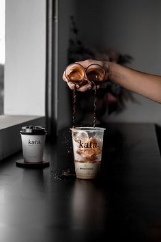 a person pouring coffee into two cups