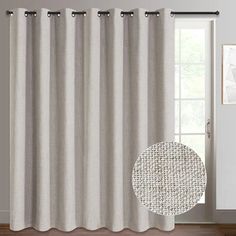 a white curtain hanging on the side of a window in front of a wooden floor