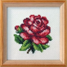 a cross stitch rose in a wooden frame