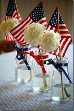 three vases with american flags and flowers in them