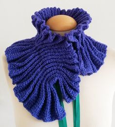 a purple knitted scarf on a mannequin's neck with a wooden button