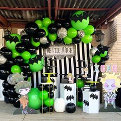 a bunch of balloons that are in front of a sign and some black and white decorations