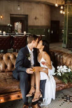 a man and woman sitting on a couch kissing