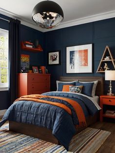 a bedroom with blue walls and orange accents