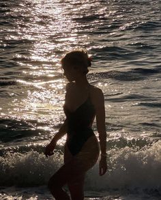 a woman in a bathing suit standing on the beach