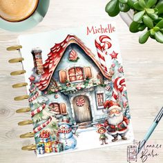 a notebook with a christmas scene on it and a cup of coffee next to it