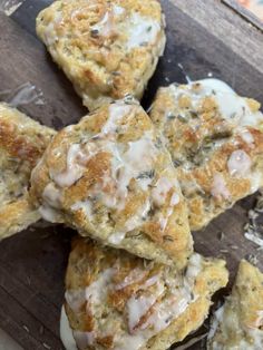 biscuits with icing on top sitting on a cutting board