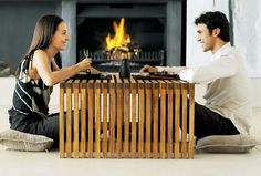 a man and woman sitting in front of a fire place