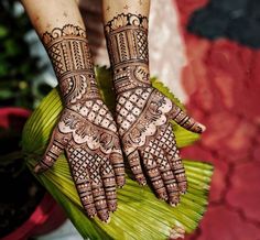 two hands with henna designs on them