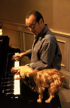 a man playing the piano with his dog