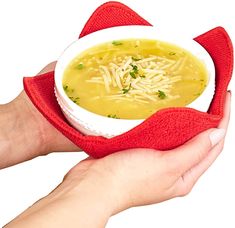 a person holding a bowl of soup in their hand