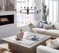 a living room filled with furniture and a fire place in front of a window on top of a rug