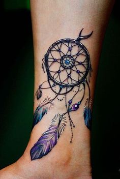 a woman's foot with a tattoo on it that has a small dream catcher