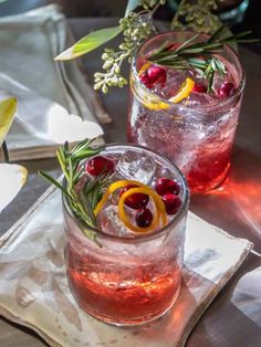 two glasses filled with drinks sitting on top of a table