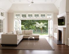 a large living room with white furniture and wood floors