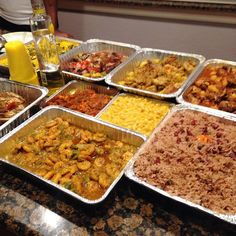 many trays of food are sitting on the counter