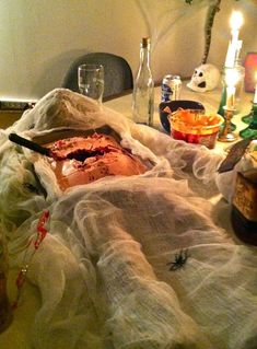 the table is covered with white cloths and candles, which are also decorated for halloween