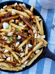 a skillet filled with french fries covered in caramel sauce and marshmallows