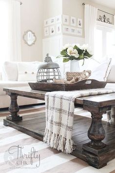 a living room with white couches and wooden coffee table in the centerpieces