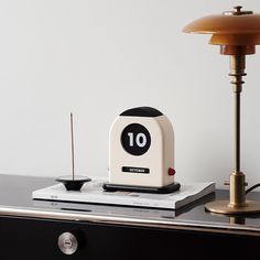 an alarm clock sitting on top of a table next to a lamp