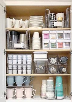 an open cabinet filled with dishes and cups