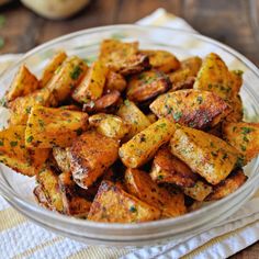 a glass bowl filled with cooked potatoes on top of a table