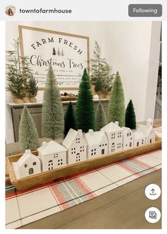 a wooden tray with christmas trees and houses on it in front of a sign that reads farm fresh christmas trees