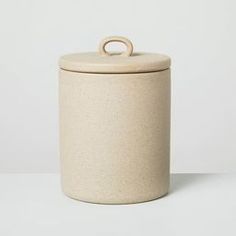 a white canister with a wooden handle