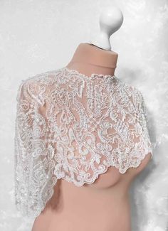 a mannequin wearing a white lace top