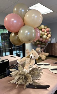 a teddy bear sitting on top of a bunch of balloons