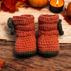 there is a pair of crocheted boots sitting on the table next to some pumpkins