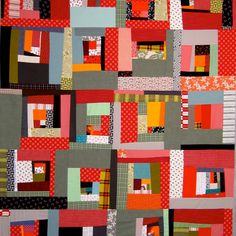 a patchwork quilt with red, orange and grey squares