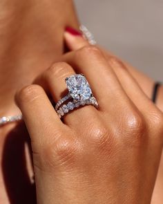 a woman's hand holding a diamond ring