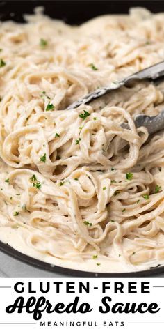 a pan filled with gluten - free alfredo sauce and garnished with parsley