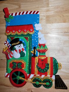 a christmas train made out of felt on top of a wooden floor