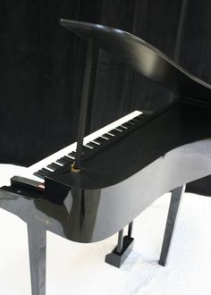 a black piano sitting on top of a white table