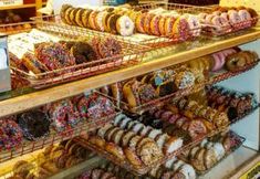 a display case filled with lots of different kinds of doughnuts and pastries