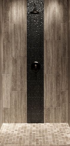 a tiled shower stall in a bathroom with blue and brown tiles on the walls, along with an overhead shower head